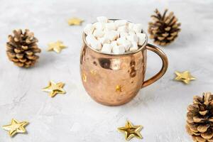 Cup of hot cocoa and marshmallows, gray background photo