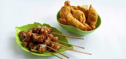 Cilor Tusuk or Pentol Telur Gulung and fried sweet banana or pisang moleng in plate on white background. It is a typical Indonesian snack. Usually Sell at Street Food. photo