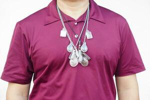 Closeup man wears necklace with  Buddha amulet on neck. Concept, faith and belief of Buddhist for holy to protect from dangers, bring good luck,charming,  business prosperity and wealth. Men fashion photo