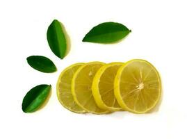 Fresh yellow lemon slice isolated on a white background with green leaves photo