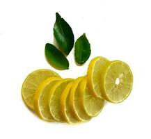 Fresh yellow lemon slice isolated on a white background with green leaves photo