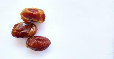 Pile of tasty dry dates isolated on white background. Kurma, buah kurma, Arabic food. photo