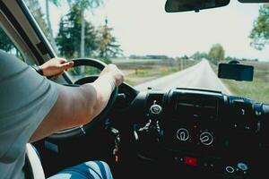 Person driving car. Man holding a steering wheel inside the big car. Transportation. Driving. photo