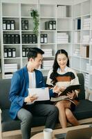 Two business workers talking on the smartphone and using laptop at the home office. photo