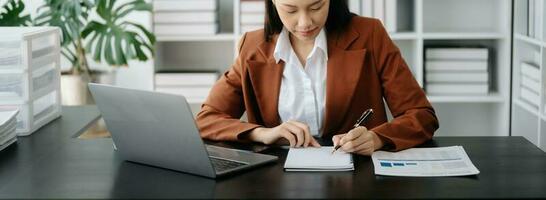 Business woman sitting front tablet ,laptop computer with financial graphs and statistics on monitor. photo