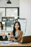 Young attractive Asian female office worker business suits smiling at camera in modern office photo