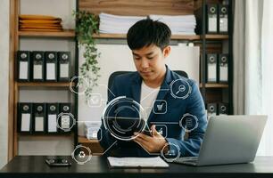 businessman hand working with mobile phone and modern compute with VR icon diagram at office in morning light photo