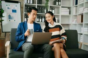 Businesswomen work and discuss their business plans. A Human employee explains and shows her colleague the results paper in modern office. photo