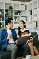 Businesswomen work and discuss their business plans. A Human employee explains and shows her colleague the results paper in modern office. photo