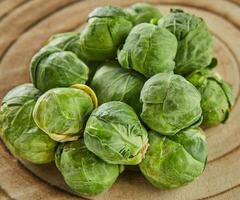 Brussels sprouts stacked in pile on wooden background photo