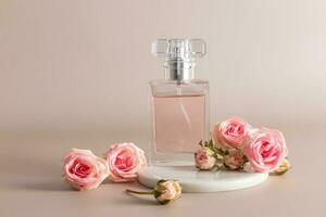 Beautiful cosmetic perfume bottle on a white round catwalk with small pink roses. front view. Blank bottle layout. Product advertising. photo