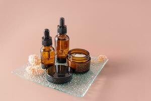 Multifunctional moisturizing serum and cream for face and body skin care in a cosmetic set of natural self-care products. Brown background. photo