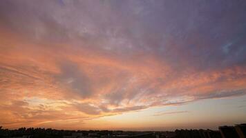 The beautiful sunset view with the buildings' silhouette and orange color sky as background in the city photo