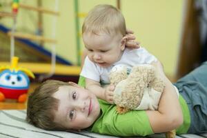 julio 20, 2019 bielorrusia, ciudad de gomil jardín de infancia en el ciudad. dos pequeño hermanos son jugando en el alfombra. foto
