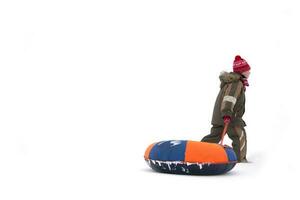 Child in winter. A boy with sledges and cheesecakes is walking in the snow. photo