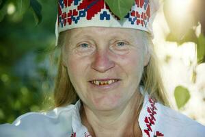 retrato de un sonriente eslavo mayor mujer en un nacional tocado con un sonrisa. foto