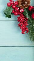 On a turquoise wood background, a decoration of a spruce branch and cones. Christmas background. photo