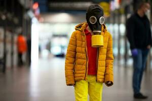 coronovirus proteccion. un niño en un gas máscara con un coronovirus infección. chico en un Tienda en personal protector equipo. hombre defiende él mismo en contra codicioso 19 foto