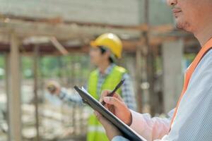 inspector or engineer is inspecting construction and quality assurance new house using a checklist. Engineers or architects or contactor work to build the house before handing it over to the homeowner photo