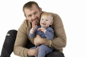 Over white background happy dad with one-year-old toddler smiling and looking at the camera. photo