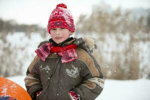 Children in winter. Cheerful boy in warm winter clothes. photo