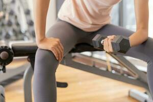 asian woman is lifting the Dumbbell up to her head to strengthen her arms and shoulders. exercisers and are checking how to exercise properly. correct exercise. diet, body shape, healthy, strong photo