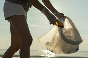 ahorrar agua. los voluntarios recogen basura en la playa y las botellas de plástico son difíciles de descomponer para evitar dañar la vida acuática. tierra, ambiente, planeta verde, reducir el calentamiento global, salvar el mundo foto