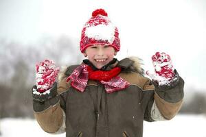 Children in winter. The happy boy plays in the snow. photo