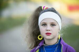 The face of a little girl with bright makeup. A child in the style of the nineties. photo