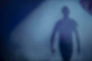 Blurred silhouette of a man in stage smoke. The departing ghost of a man. Dream mystical background with man. photo