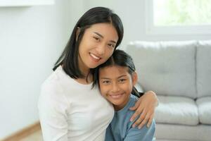 single mom happy together with daughter. Asian young mother smile and hug daughter in home. love, encouragement, take care of each other family warmth, reducing teenage and social problem, feel goods photo