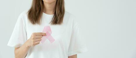 Woman hold pink ribbon breast cancer awareness. Female health check consciousness. international Women Day and World Cancer Day. sign cancer, Symbolic, health care, support patients, timely diagnosis photo