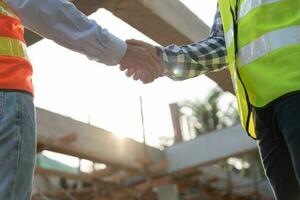 Construction worker team hands shaking greeting start up plan new project contract in office center at construction site, industry ,architecture, partner, teamwork, agreement, property, contacts. photo