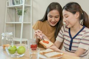 LGBT. Asian lesbian couple smiling and showing love while having breakfast at home. Young asian couple hugging each other happily, lovers, homosexuality, homosexuality, freedom, expressions photo