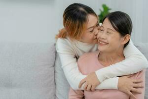 Mother day, cute asian teen girl hugging and kissing on the cheek, mature middle age mum. Love, kiss, care, happy smile enjoy family time. celebrate special occasion, happy birthday, merry Christmas. photo