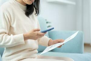 Modern woman use phone to scan barcode or QR codes to pay credit card bill after receive document invoice. payment, receive, paying electricity, digital payments without money, technology, scanning photo