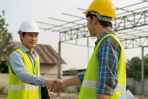 Construction worker team hands shaking greeting start up plan new project contract in office center at construction site, industry ,architecture, partner, teamwork, agreement, property, contacts. photo