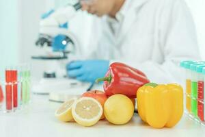 el científico comprueba los residuos de frutas químicas en el laboratorio. los expertos en control inspeccionan la concentración de residuos químicos. peligros, estándar, encontrar sustancias prohibidas, contaminar, microbiólogo foto