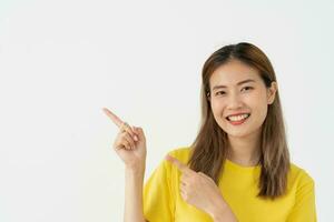 Portrait asian beautiful girl pointing blank space isolated background. Happy woman pointing on something. young female standing pointing finger sideways, billboard, introduction, advertisement, space photo