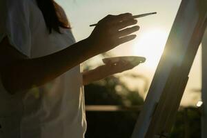 la artista femenina profesional usa pincel en el arte abstracto para crear una obra maestra. pintura de pintor con acuarelas o aceite en casa de estudio. bella mujer disfruta pintando como hobby. recreación laboral foto