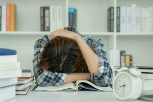 las estudiantes asiáticas tienen ansiedad debido a los exámenes, las mujeres se preparan para las pruebas y aprenden lecciones en la biblioteca. estrés, desesperación, prisa, malentendido lectura, desaliento, expectativa, conocimiento foto