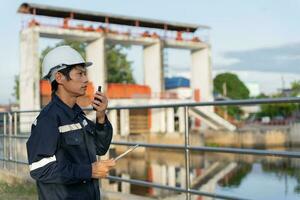 maintenance and inspector. Maintenance engineers are using tablet to checking results of inspection of buildings and structures. Irrigation engineers are exploring sluice systems photo
