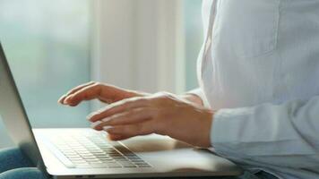 Woman is sitting on the couch and working on a laptop. Concept of remote work video