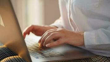 femme est séance sur le canapé et travail sur une portable. concept de éloigné travail video