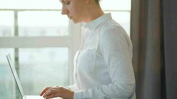 Frau ist Sitzung auf das Couch und Arbeiten auf ein Laptop. Konzept von Fernbedienung Arbeit video