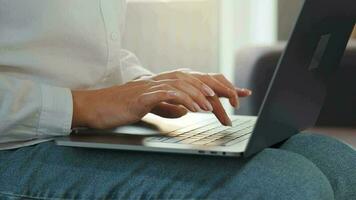 Woman is sitting on the couch and working on a laptop. Concept of remote work video