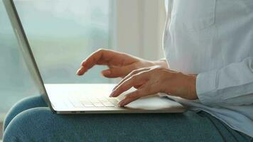 Woman is sitting on the couch and working on a laptop. Concept of remote work video