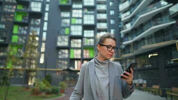 mujer caminando en un negocio distrito con compras pantalones y hablando en el teléfono inteligente urbano estilo de vida y digital video