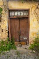 A brown wooden and old door in a stone house. photo