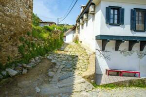 estrecho calles en un turco ciudad en un verano y soleado día con antiguo y albañilería de madera casas foto